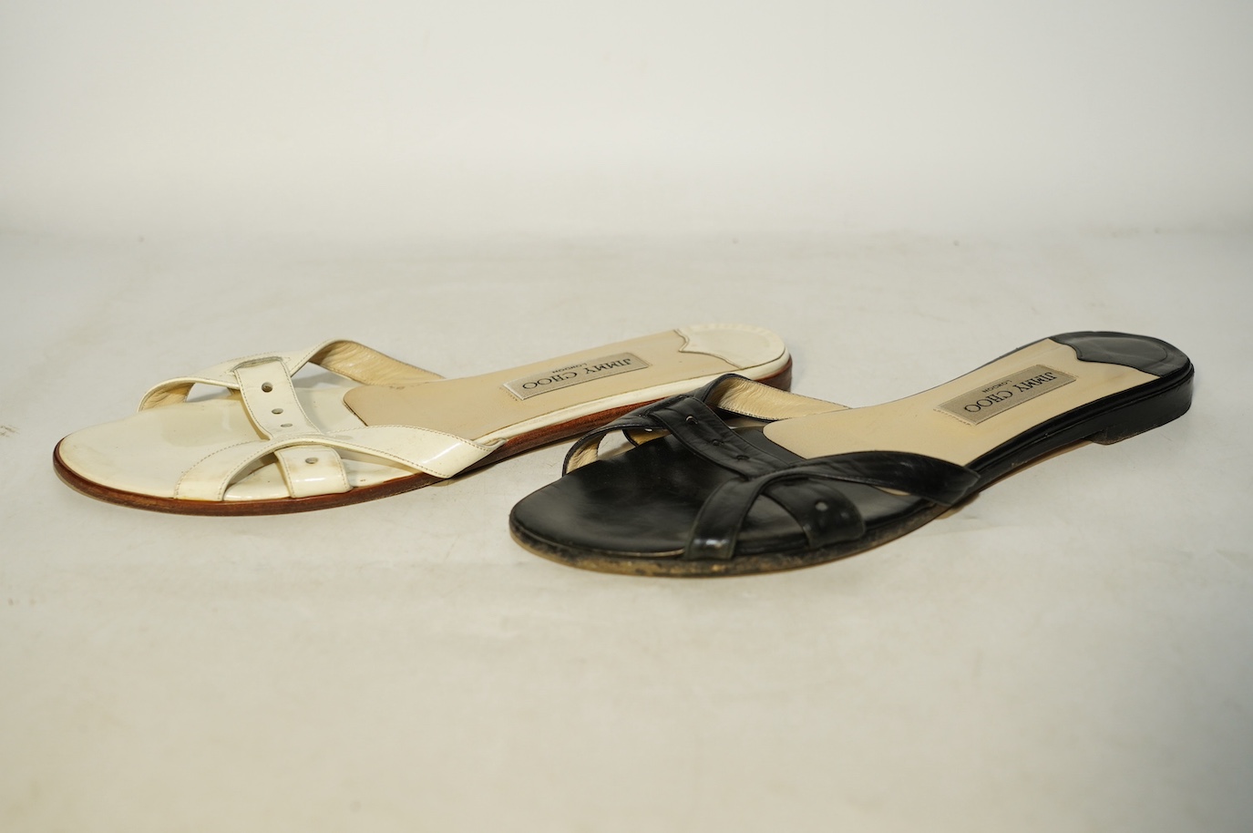 Two pairs of Jimmy Choo flat sandals, black leather and white patent leather, size 41